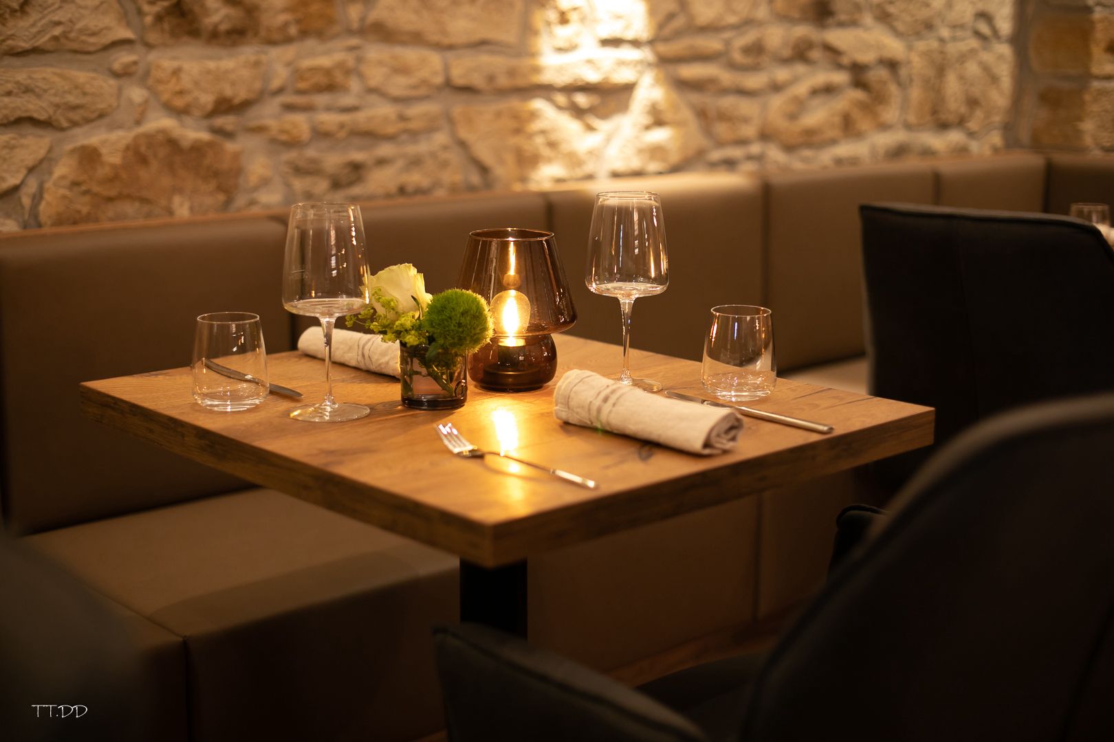 Gedeckter Tisch mit Kerzen und Weingläsern im Gastraum des HOFZWANZIG