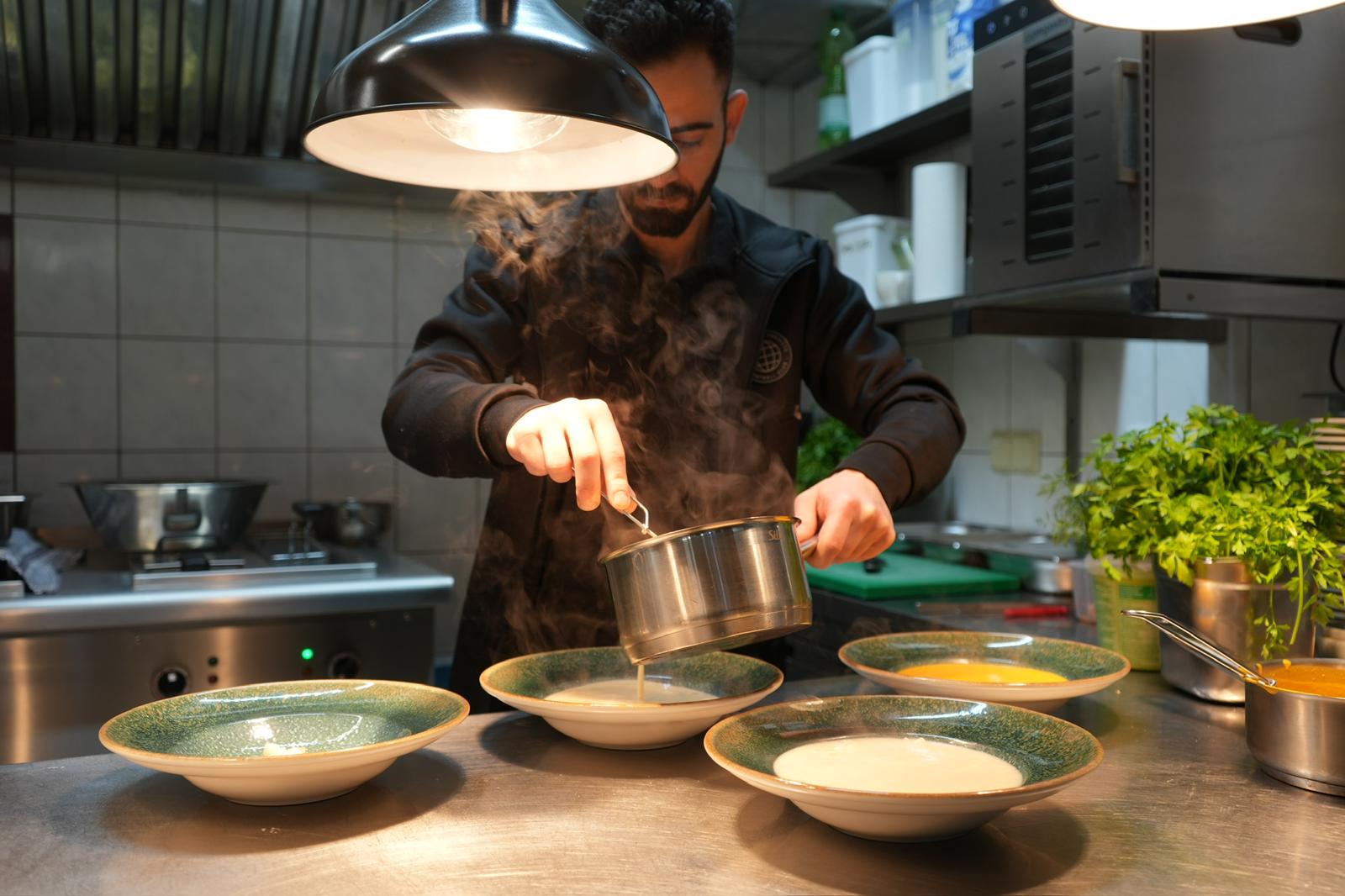 Koch bei der Zubereitung in der Kueche