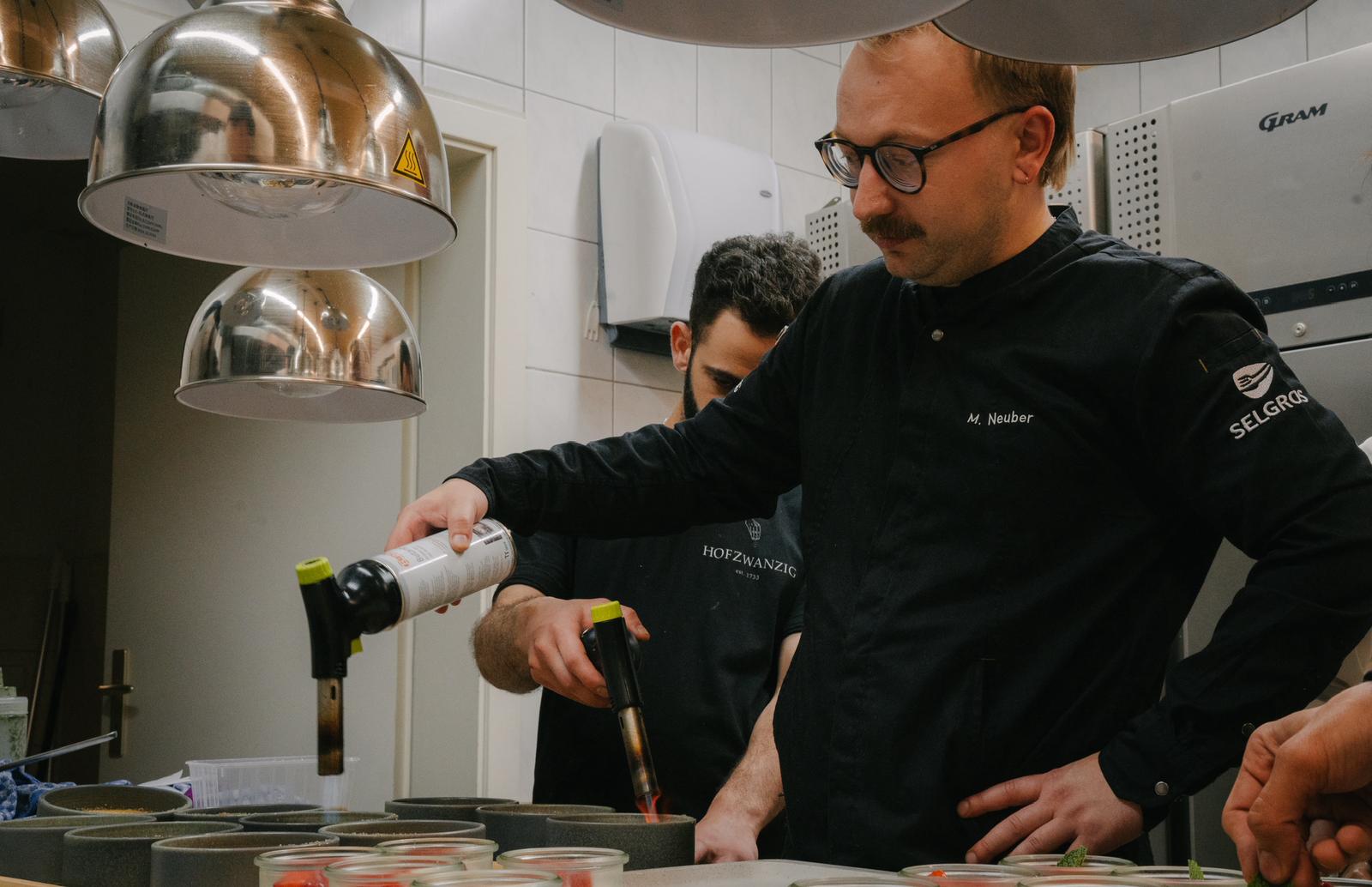 Koch richtet Hauptgericht auf Teller an